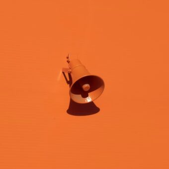 A megaphone over an orange background.